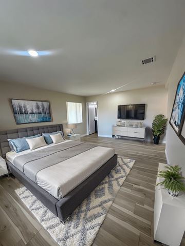 Upland apartment for rent - A bedroom with a large bed and a painting on the wall.