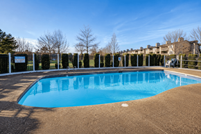 Seattle apartment for rent - A large blue swimming pool surrounded by a fence.