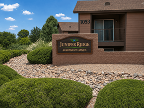 Prescott apartment for rent - A brown building with a sign that says Juniper Ridge Apartment Homes.