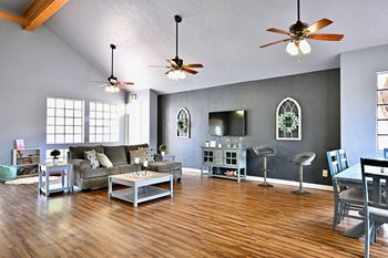 A living room with a grey couch and a wooden floor.