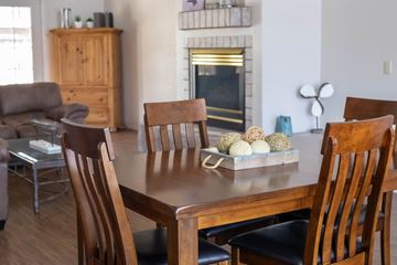 Prescott apartment for rent - a dining room table with wooden chairs and a living room with a fireplace
