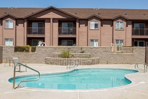 Prescott apartment for rent - a swimming pool with a building in the background at Pines at Prescott Apartments, Arizona