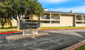 Wichita Falls apartment for rent - A sign for Brentwood Timberlane Apartments is displayed in front of a building.