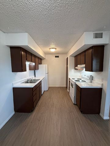 Wichita Falls apartment for rent - A kitchen with brown cabinets and white appliances.