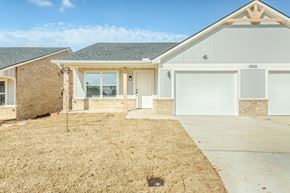 Oklahoma City triplex for rent - A house with a garage and a driveway in front.