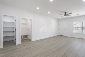 Oklahoma City triplex for rent - A spacious room with a ceiling fan and lighting fixtures.
