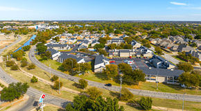 Wichita Falls apartment for rent - A road with a traffic light and a parking lot.
