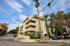 Los Angeles apartment for rent - A street view of a residential area with cars parked on the side of the road.