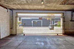 Los Angeles apartment for rent - A car is parked behind a gate in a parking garage.