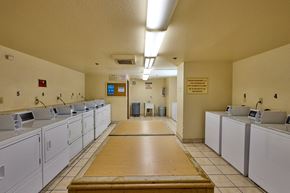 Los Angeles apartment for rent - A laundromat with washers and dryers lined up on both sides of a central aisle.
