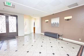 Los Angeles apartment for rent - A hallway with a bench and a door with a window.