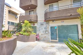 Los Angeles apartment for rent - A building with a balcony and a glass door.