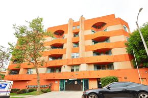 Los Angeles apartment for rent - A black car is parked in front of a building.