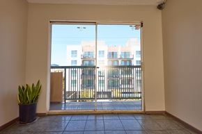 Los Angeles apartment for rent - A room with a view of a balcony and buildings outside.