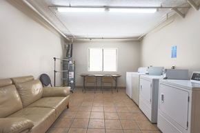Los Angeles apartment for rent - A room with a tan couch, a table, and a washing machine.