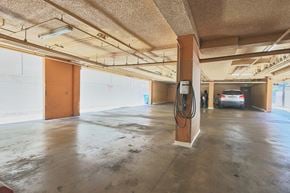 Los Angeles apartment for rent - A car is parked in a garage with a charging station.