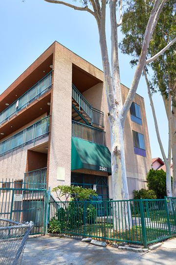 Los Angeles apartment for rent - A building with a green awning and a tree in front of it.