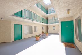 Los Angeles apartment for rent - A balcony with green railings is on the second floor of a building.