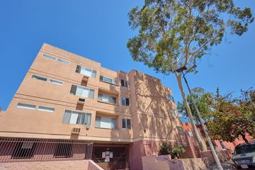 Los Angeles apartment for rent - A tall building with a tree in front of it.