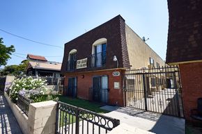 Los Angeles apartment for rent - A brick building with a gate and a sign that says "FOR LEASE".