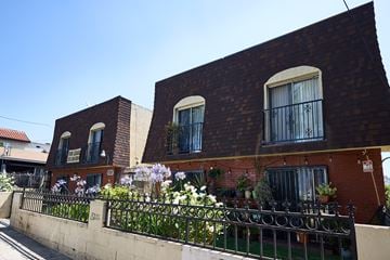 Los Angeles apartment for rent - A red brick building with a black iron fence in front.