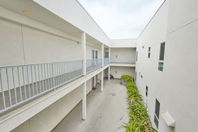 North Hollywood apartment for rent - A white building with a balcony and plants on the side.