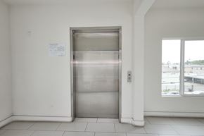 North Hollywood apartment for rent - A stainless steel elevator in a white room with a paper on the wall.