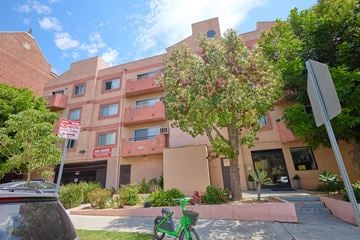 Los Angeles apartment for rent - A green bike is parked in front of a tan building.