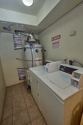 Los Angeles apartment for rent - A washing machine in a laundry room with a warning sign on the wall.
