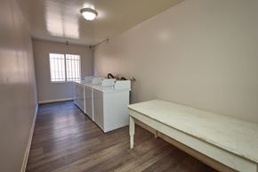 Los Angeles apartment for rent - A room with a long table and a row of beds.
