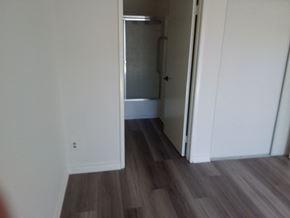 Venice apartment for rent - a closet in a white room with wooden floors and a door open