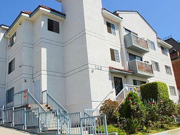 Los Angeles apartment for rent - a white apartment building with stairs and a fence