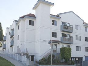 Los Angeles apartment for rent - a row of white apartment buildings on a street