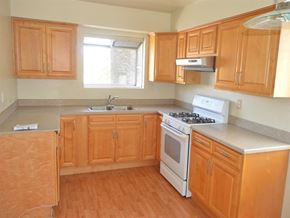 Los Angeles apartment for rent - an empty kitchen with wooden cabinets and white appliances