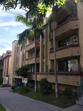 Los Angeles apartment for rent - a tall apartment building with palm trees in front of it