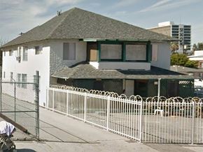 Los Angeles apartment for rent - A white house with a green roof and a white fence in front.