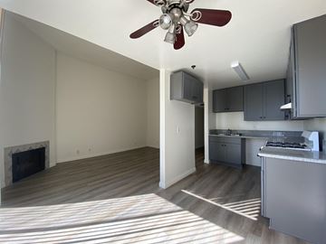 Los Angeles apartment for rent - an empty living room with a ceiling fan and a kitchen