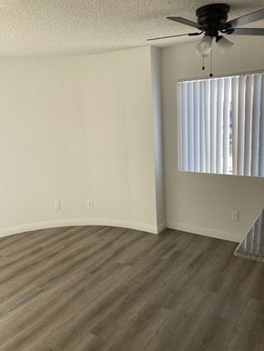 San Pedro apartment for rent - an empty living room with a window and a ceiling fan