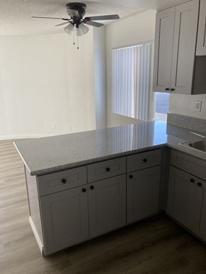 San Pedro apartment for rent - an empty kitchen with a counter top and a window