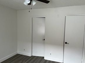 Los Angeles apartment for rent - a bedroom with white walls and a closet and a ceiling fan