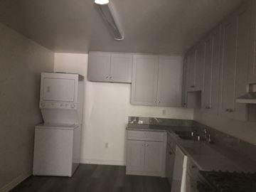 Los Angeles apartment for rent - A kitchen with white cabinets and a black counter top.