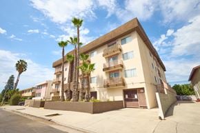Los Angeles apartment for rent - A building with a brown and beige exterior has a balcony on the second floor.