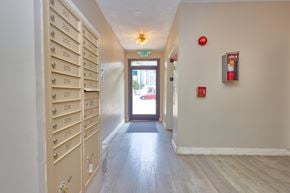 Los Angeles apartment for rent - A hallway with a row of mailboxes on the left and a door on the right.