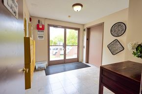 Los Angeles apartment for rent - A room with a brown door and a black and white picture on the wall.