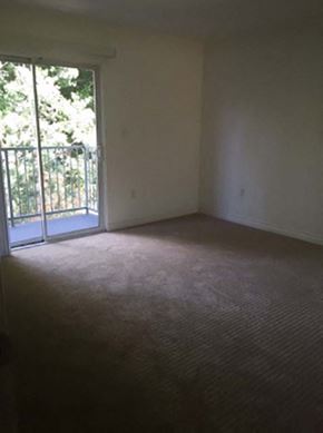 Sherman Oaks apartment for rent - an empty living room with a door to a balcony