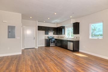 North Hollywood apartment for rent - a renovated kitchen with black cabinets and a wooden floor