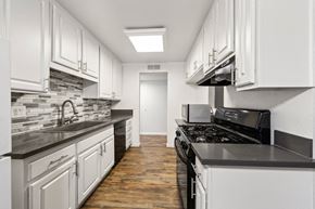 Winnetka apartment for rent - a kitchen with white cabinets and black counter tops