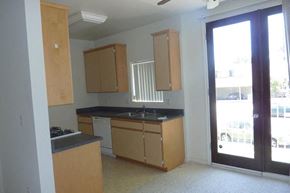 Los Angeles apartment for rent - an empty kitchen with wooden cabinets and a glass door