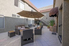 Canoga Park apartment for rent - a patio with chairs and an umbrella