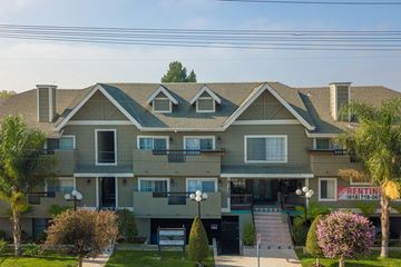 Canoga Park apartment for rent - a large apartment building with a porch and a street sign